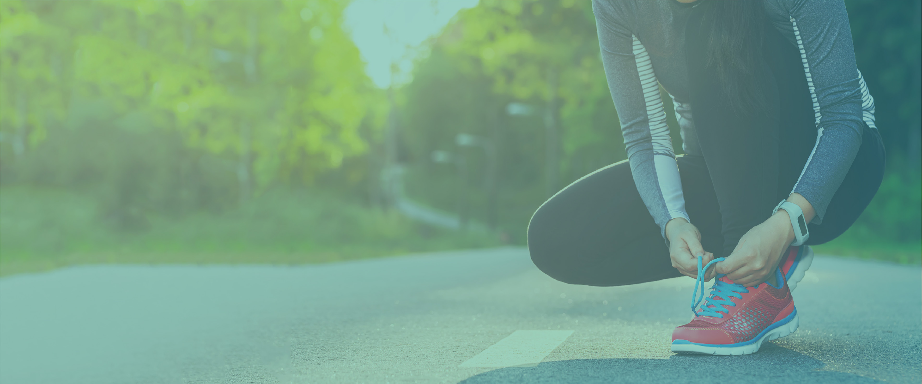 woman tying shoe on the side of the road